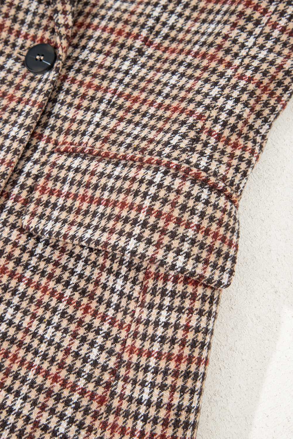 Close-up of front pocket and sleeve on Ladies Brown Houndstooth Fitted Blazer, highlighting structured tailoring and pattern.