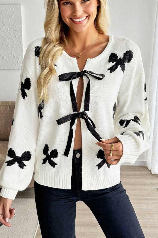 Women’s White Bow‑Lace Knit Cardigan featuring black bow patterns and ribbon tie closure, ideal for romantic spring or fall outfits.