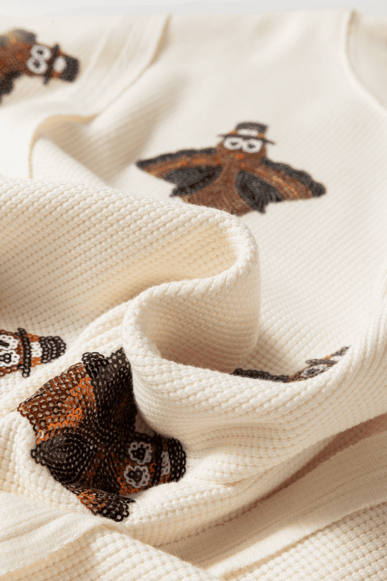 Close-up of a textured fabric Thanksgiving Oversized Knit Top.