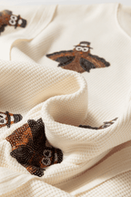 Close-up of a textured fabric Thanksgiving Oversized Knit Top.