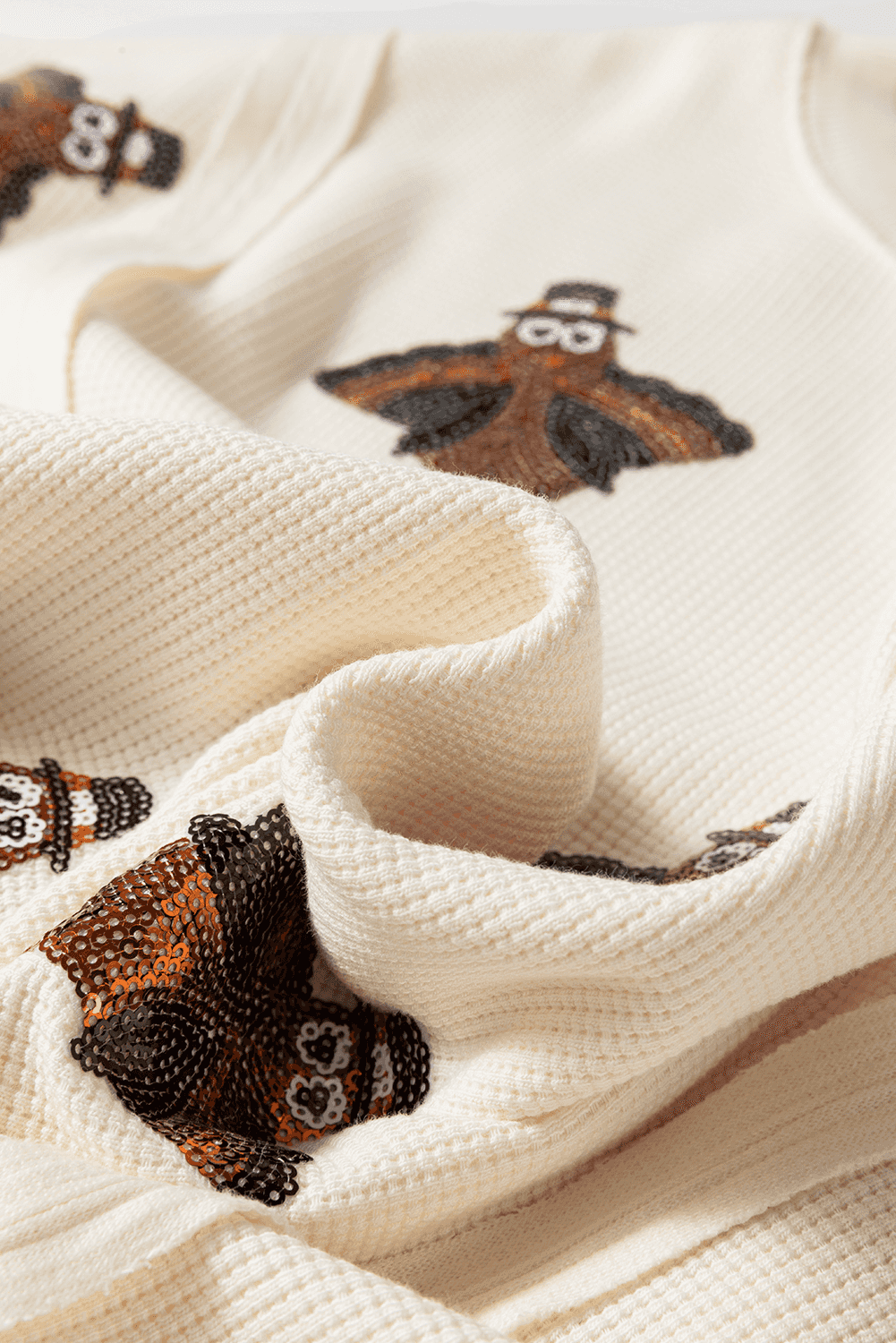 Close-up of a textured fabric Thanksgiving Oversized Knit Top.