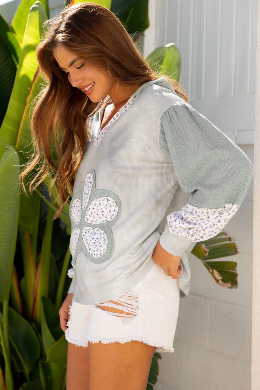 Floral Applique Oversize Hoodie in pear-green waffle knit with V-neck and floral patchwork, styled with white distressed shorts for fall fashion.