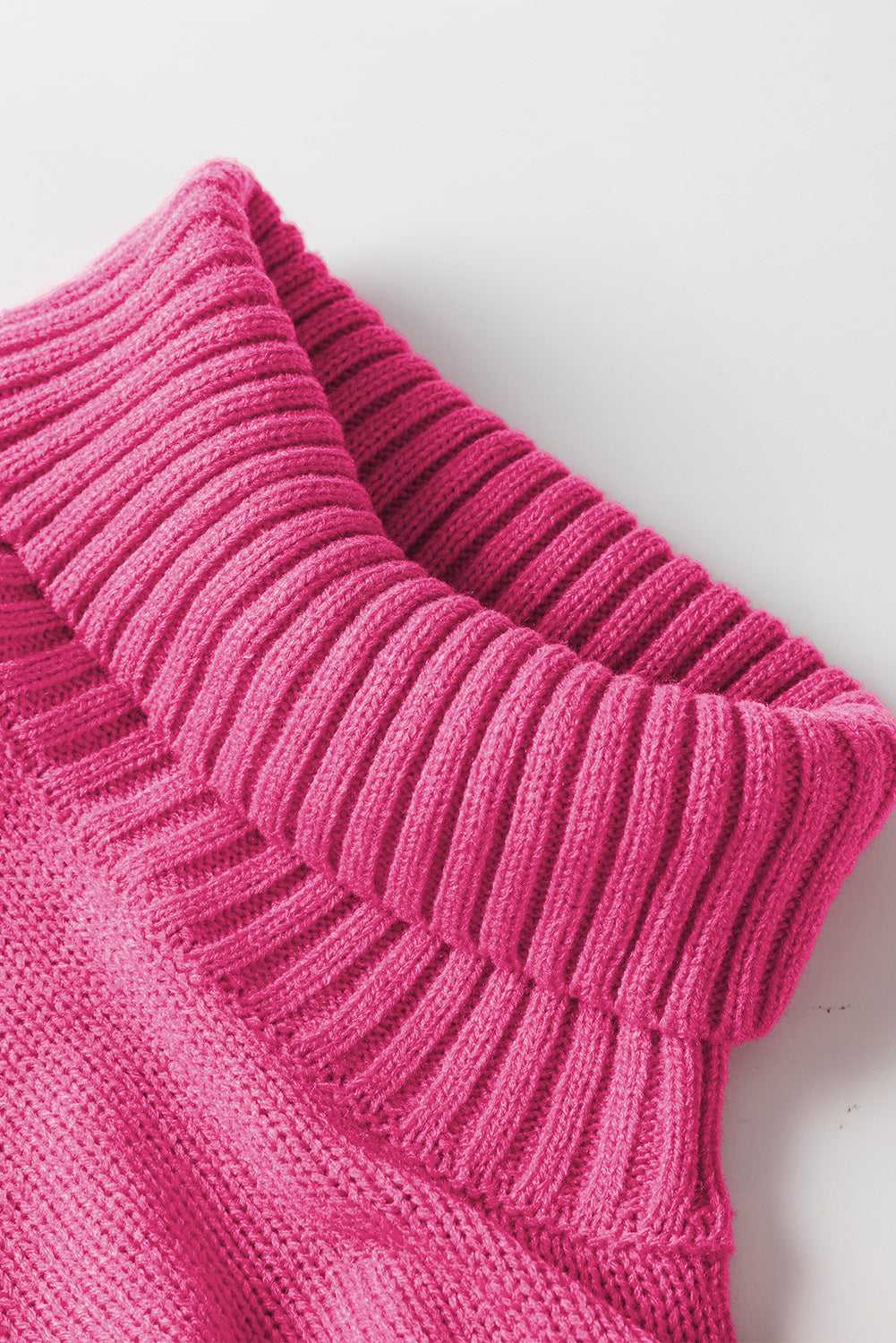 Detailed view of ribbed high neck collar on pink sweater, crafted for warmth and festive seasonal style.