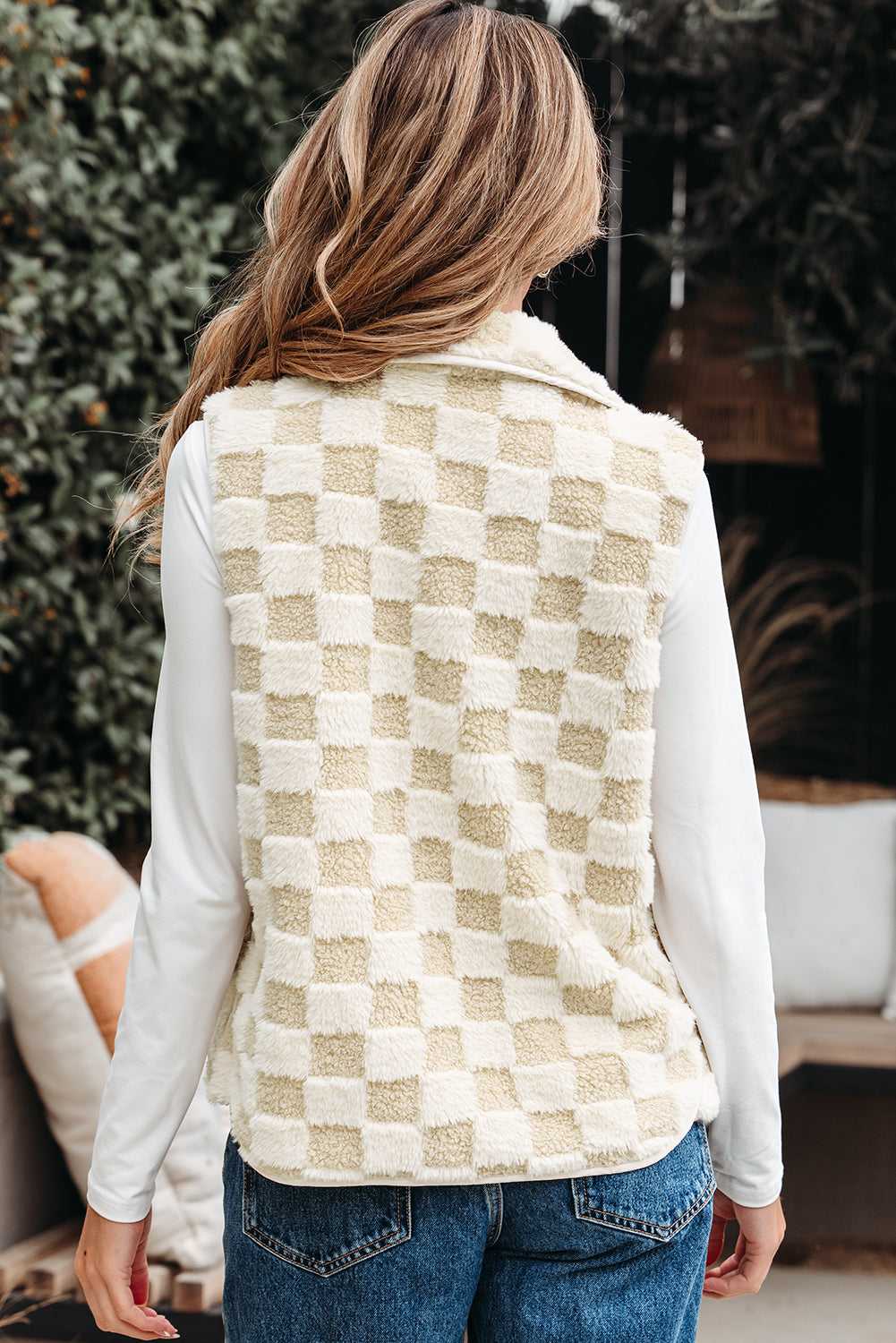 Person wearing a Sherpa Fleece Vest over a white shirt with a blurred background