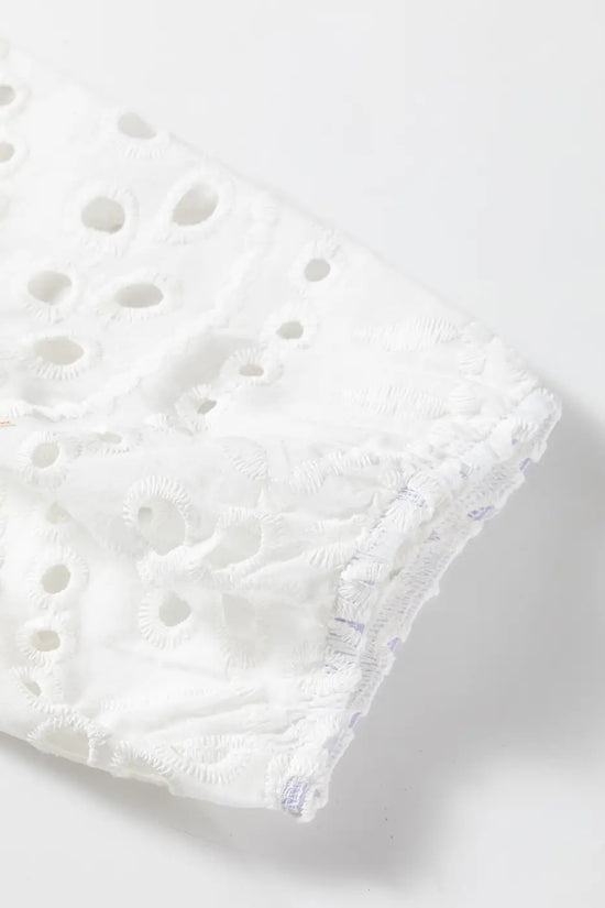 Detailed view of puff sleeve hem on White Cutwork Embroidered Crop Top, showcasing elastic finish and cutwork design.