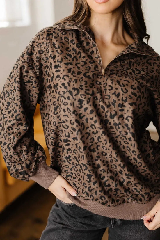 Close-up of Women's Brown Leopard Print Corduroy Half-Zip Jumper showing textured corduroy fabric and ribbed cuffs.