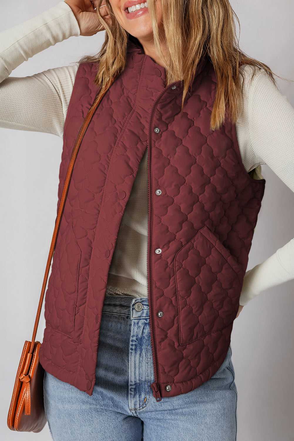 Flower‑Quilted Winter Gilet in burgundy with zip and snap buttons, styled with casual jeans and long-sleeve top for cozy winter layering.