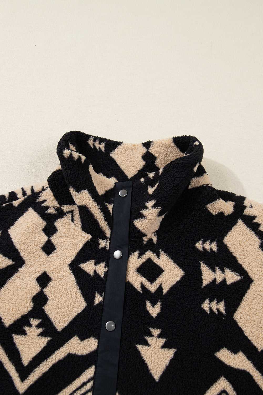 Close-up of snap-button collar on Women's Black Plus Size Aztec Print Plush Sweatshirt, highlighting high neck design and fleece material.