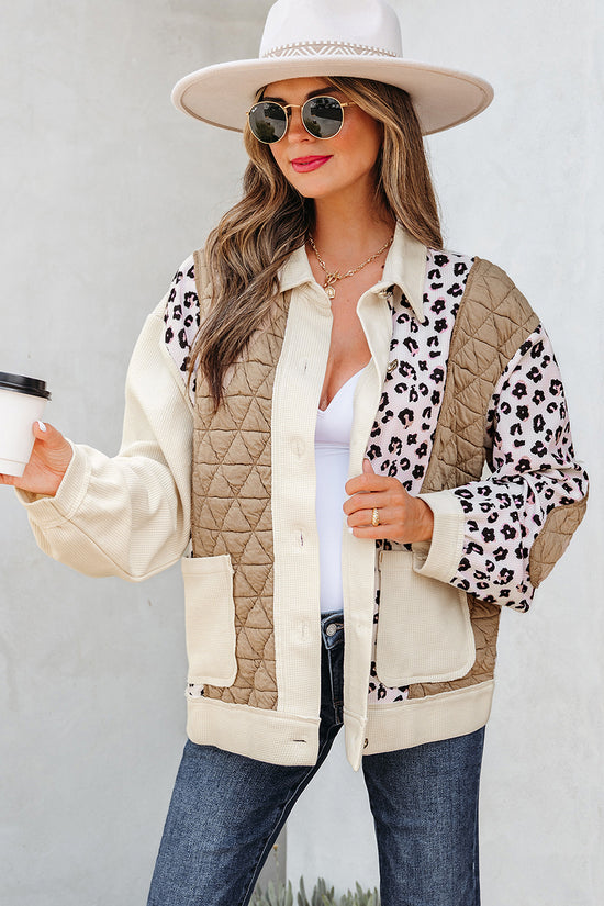 Woman wearing a beige quilted jacket with leopard print accents, holding a coffee cup.