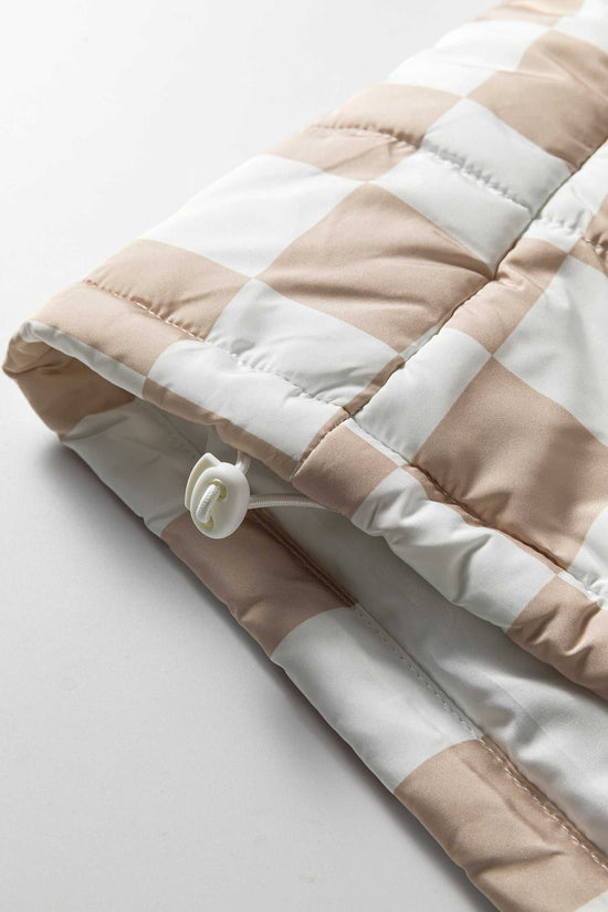 Close-up of adjustable drawcord hem on khaki plaid quilted gilet, designed for a snug fit and added warmth in winter.