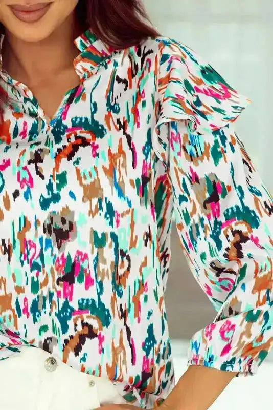 Detail shot of Abstract Ruffle Blouse with Puff Sleeves showing ruffle accents and multicolor abstract pattern.