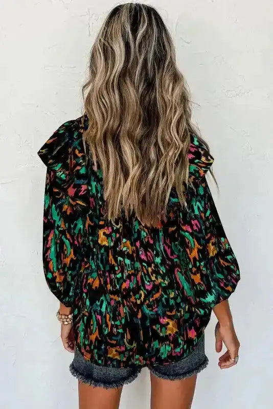 Back view of black Abstract Ruffle Blouse with Puff Sleeves, showing colorful pattern and relaxed silhouette.