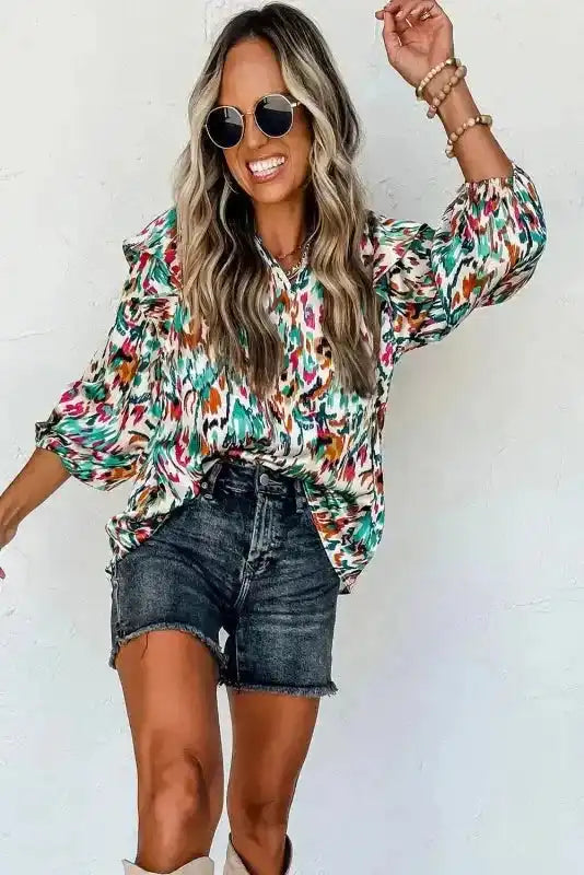 Model dancing in Abstract Ruffle Blouse with Puff Sleeves, featuring a colorful abstract pattern and casual shorts.