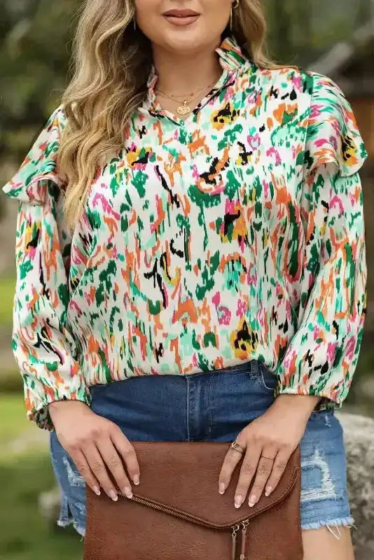 Close-up of Abstract Ruffle Blouse with Puff Sleeves, highlighting colorful abstract floral design and soft ruffle neckline.