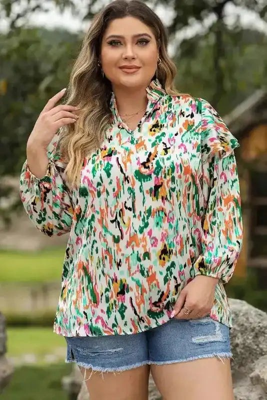 Plus-size model in Abstract Ruffle Blouse with Puff Sleeves and multicolor print, styled with denim shorts for a relaxed look.