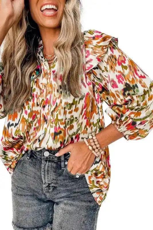 Close-up of Abstract Ruffle Blouse with Puff Sleeves in orange-pink tones, highlighting ruffle and puff sleeve details.