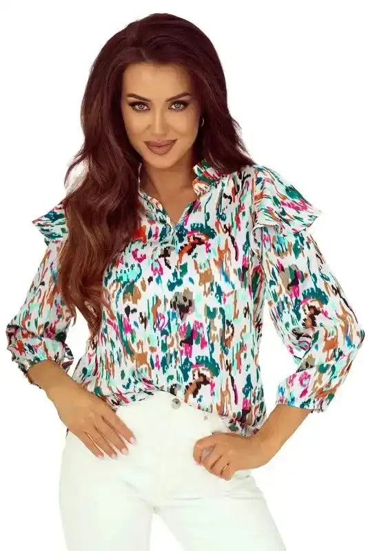 Model wearing Abstract Ruffle Blouse with Puff Sleeves tucked into white pants, perfect for chic casual wear.