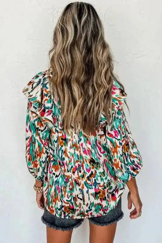 Back view of teal-toned Abstract Ruffle Blouse with Puff Sleeves, showcasing bold colors and relaxed fit.