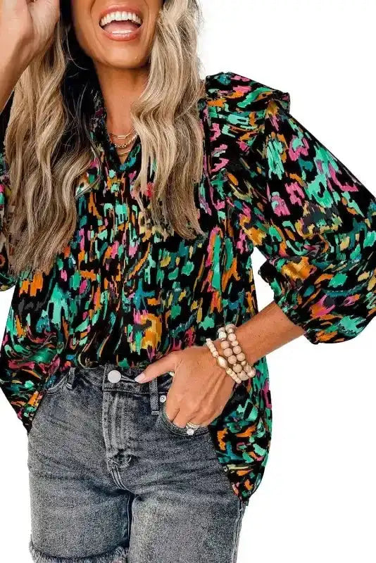 Close-up of black Abstract Ruffle Blouse with Puff Sleeves, highlighting bold print and ruffle shoulder detail.