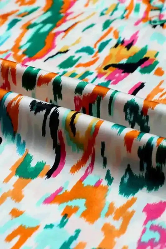 Detailed fabric view of Abstract Ruffle Blouse with Puff Sleeves showing colorful abstract print and smooth texture.