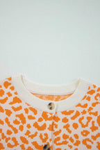 Orange chunky knit cardigan layered over neutral basics