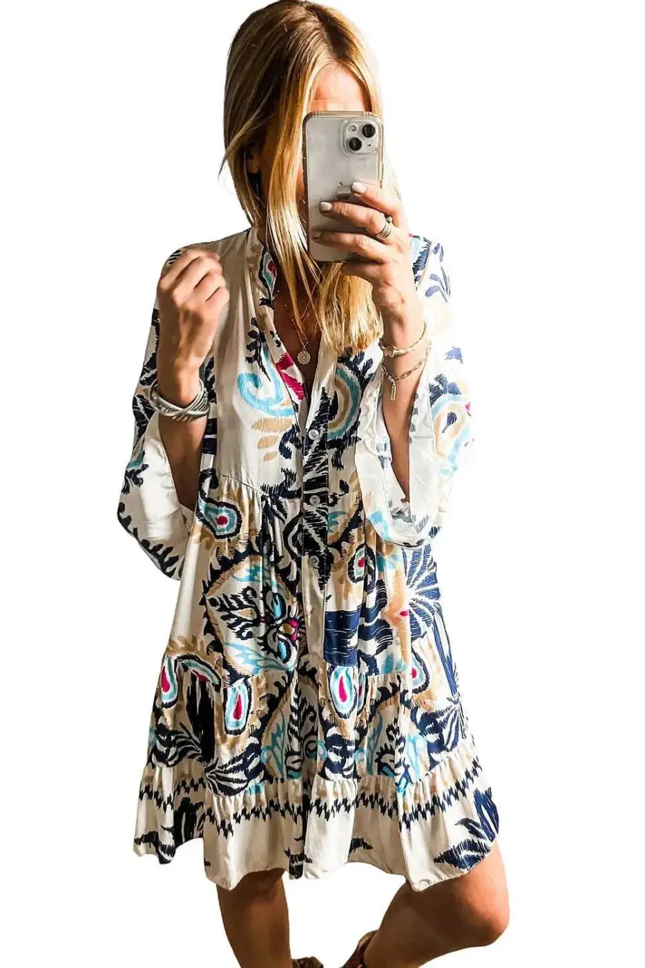 Woman taking mirror selfie in Tribal Mini Dress with bracelet sleeves, showcasing its relaxed fit and colorful bohemian print.