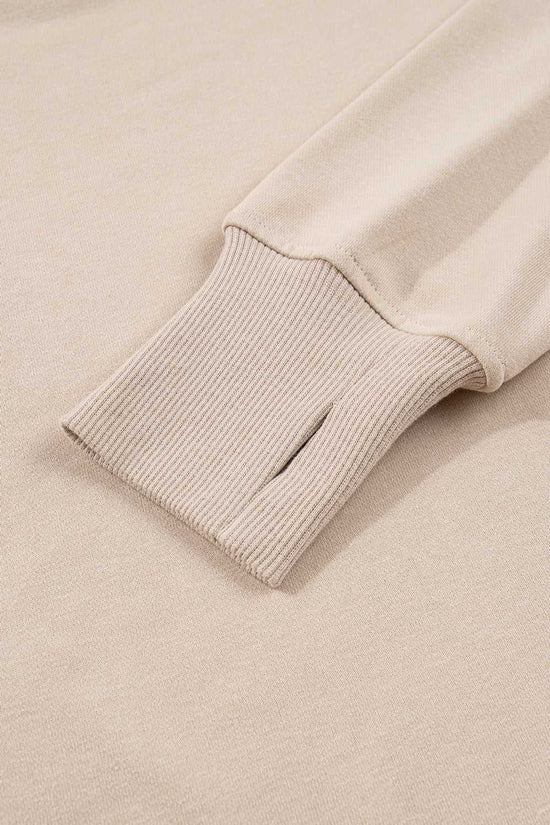 Close-up of ribbed cuff with thumbhole on beige Oversized Sweatshirt, part of the cozy and functional Matching Set for women.