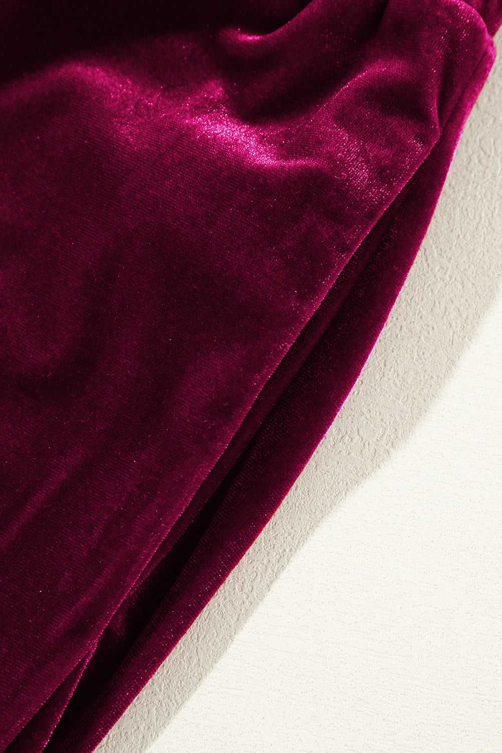 Detail of plush burgundy velvet fabric and side seam of yoga pants, emphasizing soft texture and premium finish for daily wear.