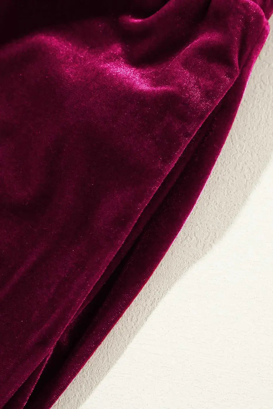 Detail of plush burgundy velvet fabric and side seam of yoga pants, emphasizing soft texture and premium finish for daily wear.