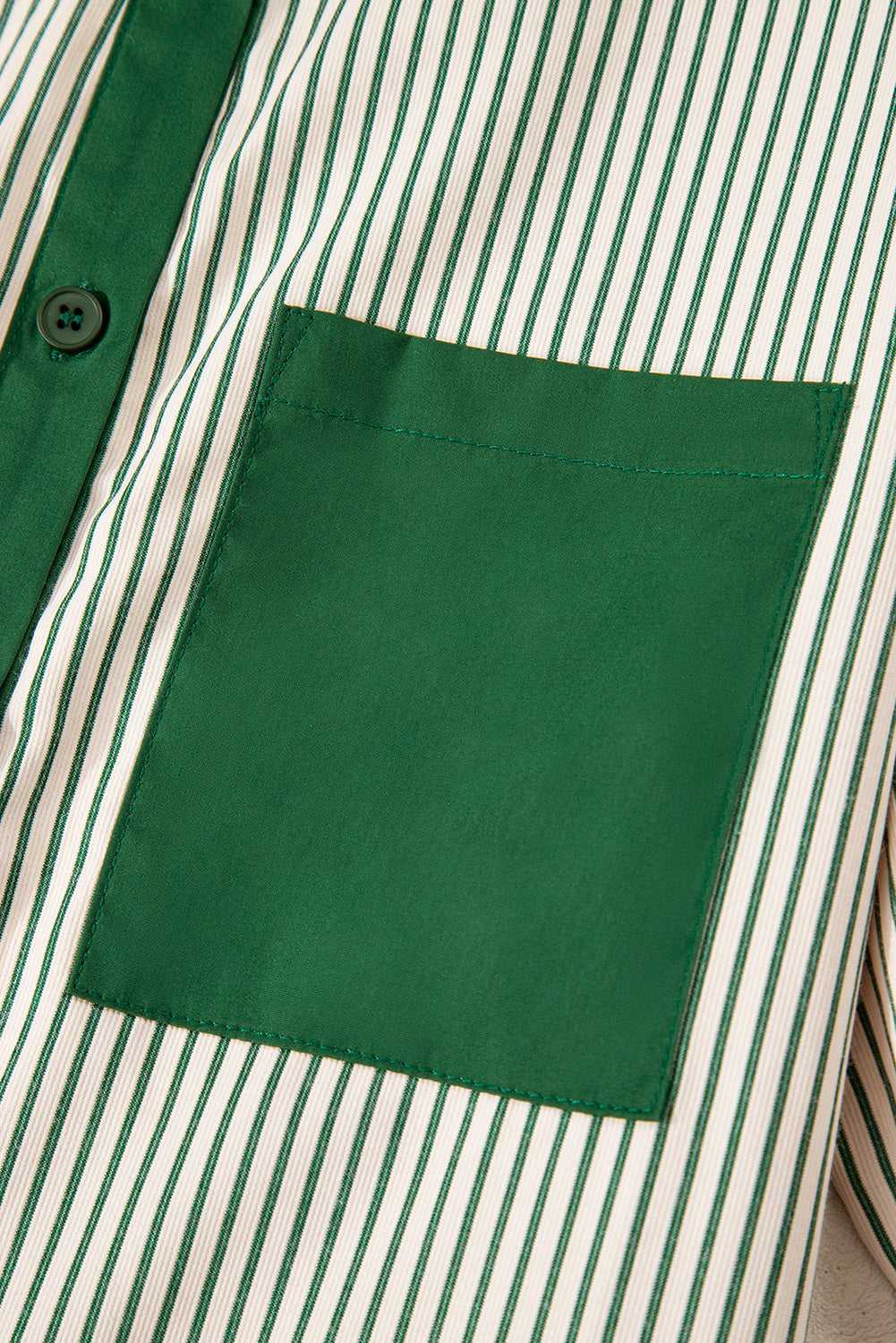 Detail of green pocket on striped mini dress, highlighting the modern monochrome design and casual summer style.
