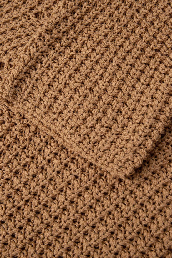 Detailed view of brown wide sleeve hollow knit jumper fabric and sleeve, highlighting the soft, airy knit texture.