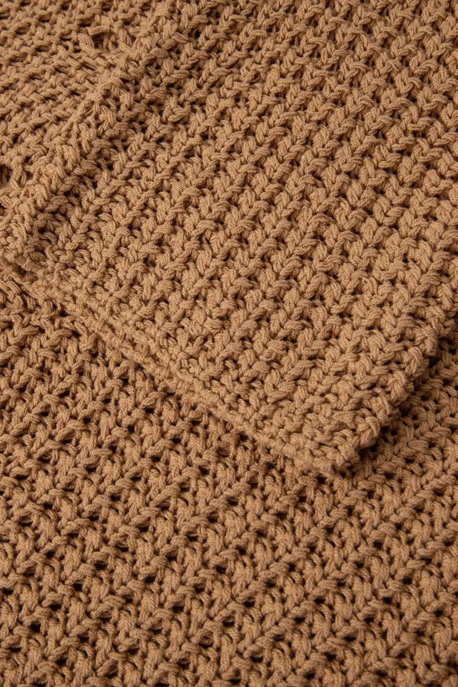 Detailed texture view of brown wide sleeve hollow knit jumper sleeve and body, showcasing soft, open-knit construction.