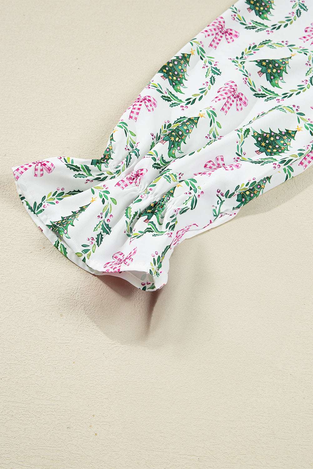 Sleeve detail of White Christmas Print Velvet Trim Pyjamas with gathered cuff and holiday wreath and bow pattern on soft fabric.