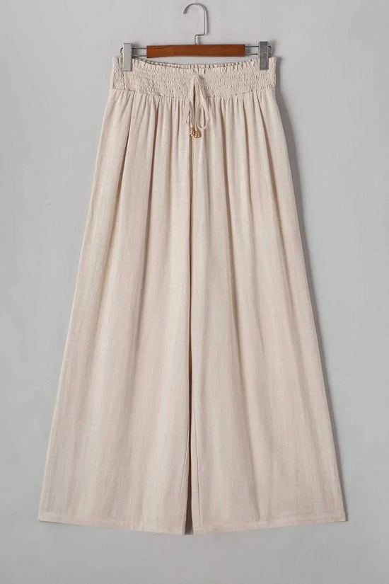 Flat lay of Wide Leg Plus Linen Pants in beige on hanger, showing full length and wide leg cut. Lightweight plus size trousers for spring fashion.
