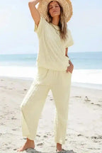 Model poses in Apricot Lattice Set - Two Piece featuring a textured batwing top and flared pants, perfect for loungewear.
