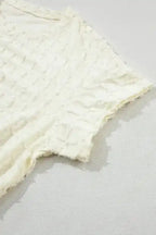 Close-up of batwing sleeve from Apricot Lattice Top, featuring soft textured fabric and relaxed fit.