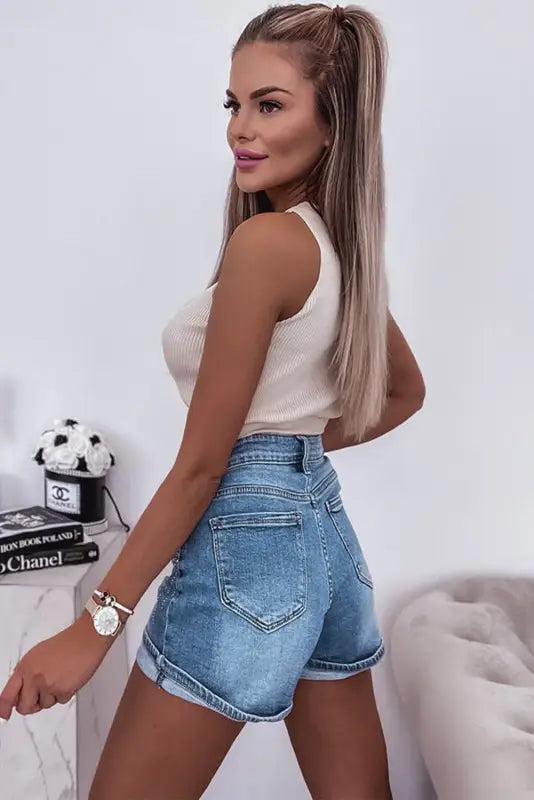 Woman in white tank top wearing ashleigh blue rhinestone denim shorts; relax relax