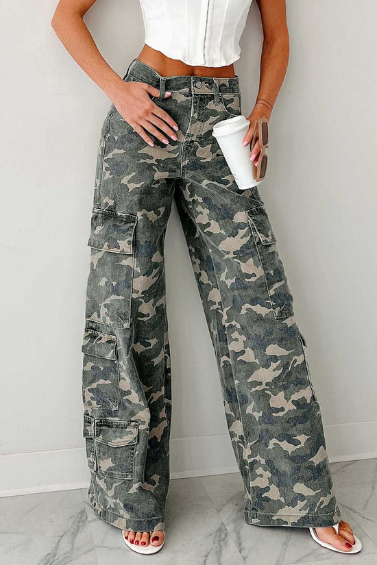 Front view of camo cargo jeans women styled with a white top. Wide leg denim pants with utility pockets and high waist in green camo print.