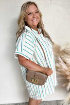 Woman wearing a striped shirt holding a Dior handbag against a neutral background
