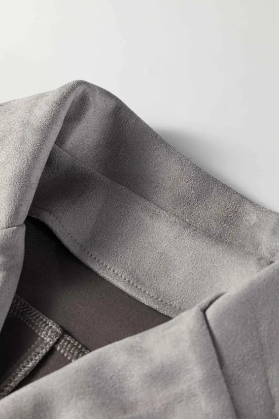 Close-up of collar on gray cropped fringe faux suede jacket, highlighting soft faux suede texture and clean tailoring.