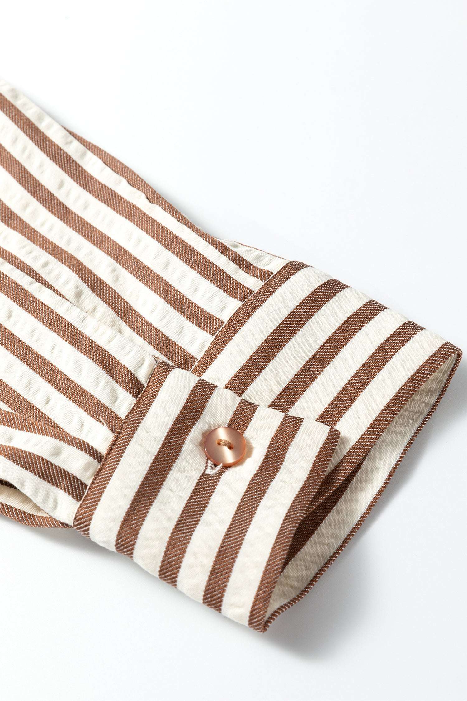 Cuff detail of brown striped midi shirt dress with button closure, showcasing lightweight fabric and casual style.