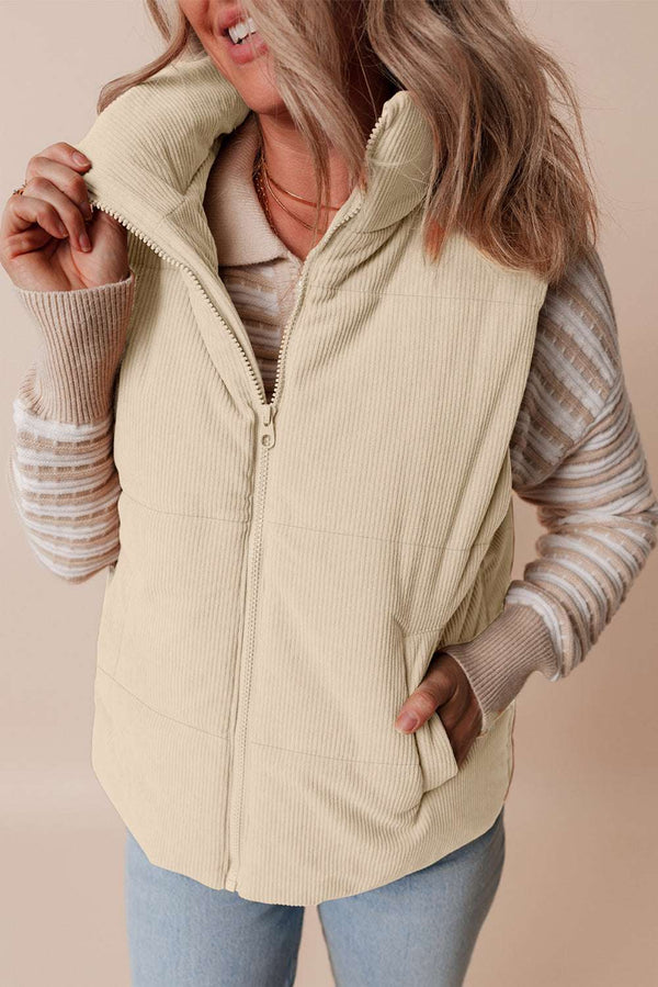 Close-up front view of ladies beige corduroy puffer gilet with stand collar and zip closure, styled for cozy winter layering.