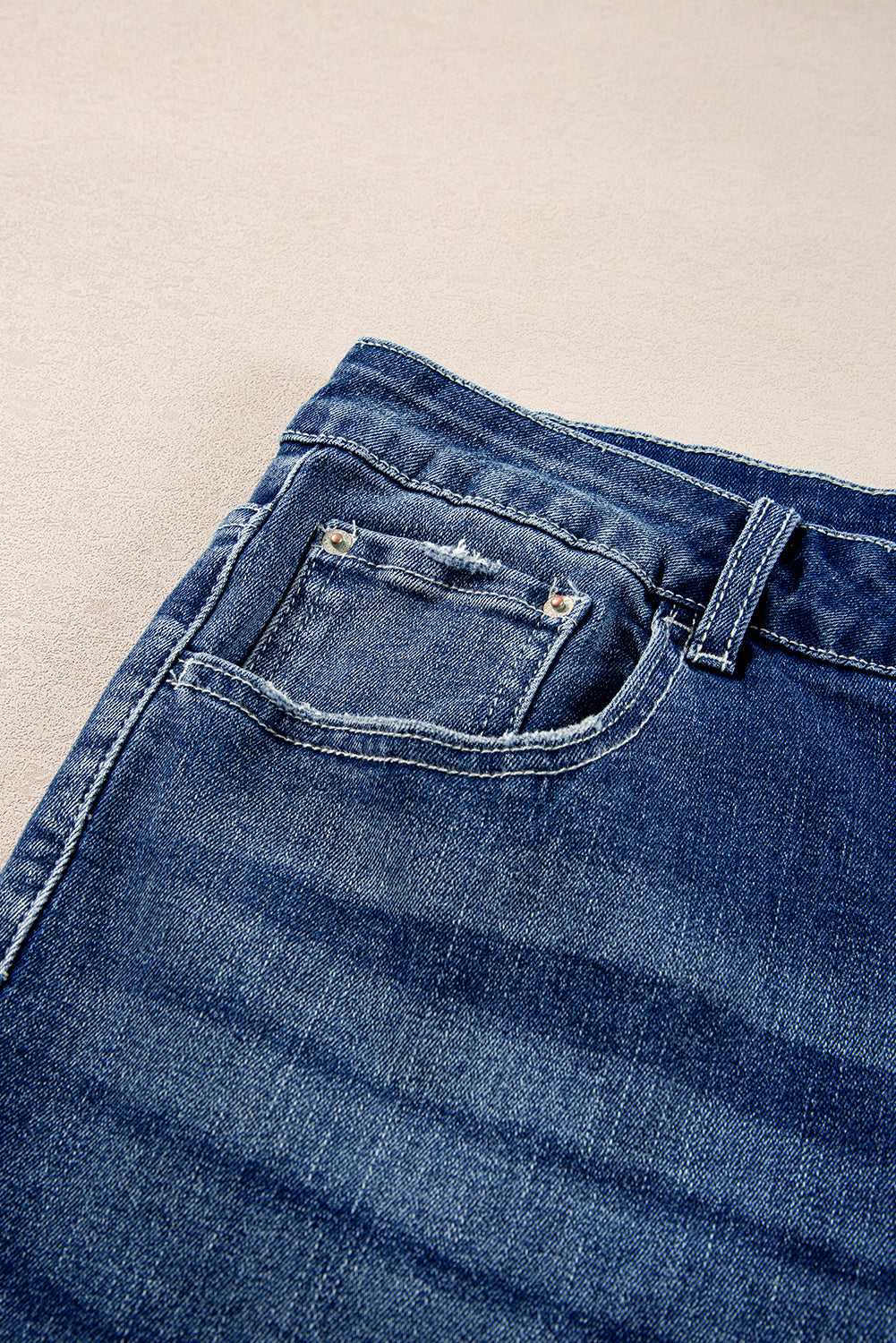 Close-up of Dirty Blue Side‑Slit Flare Jeans – Curve front pocket and waistband, showcasing denim texture and stitching details.
