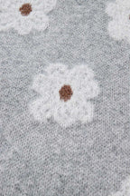 Close-up of floral knit pattern on FashionFitz Oversized Grey Floral Knit Jumper – V‑Neck highlighting fluffy white flowers on grey base.