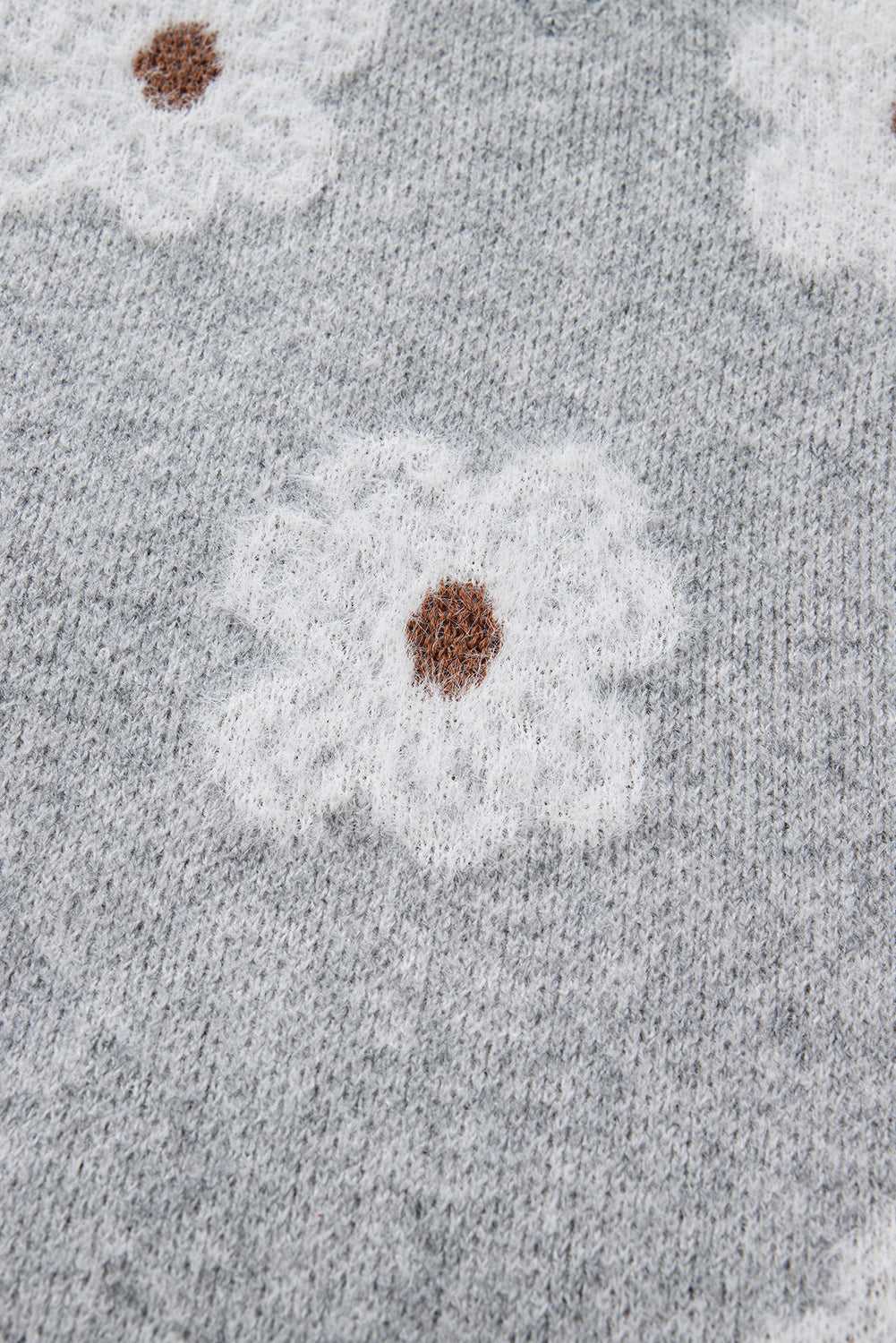 Close-up of floral knit pattern on FashionFitz Oversized Grey Floral Knit Jumper – V‑Neck highlighting fluffy white flowers on grey base.