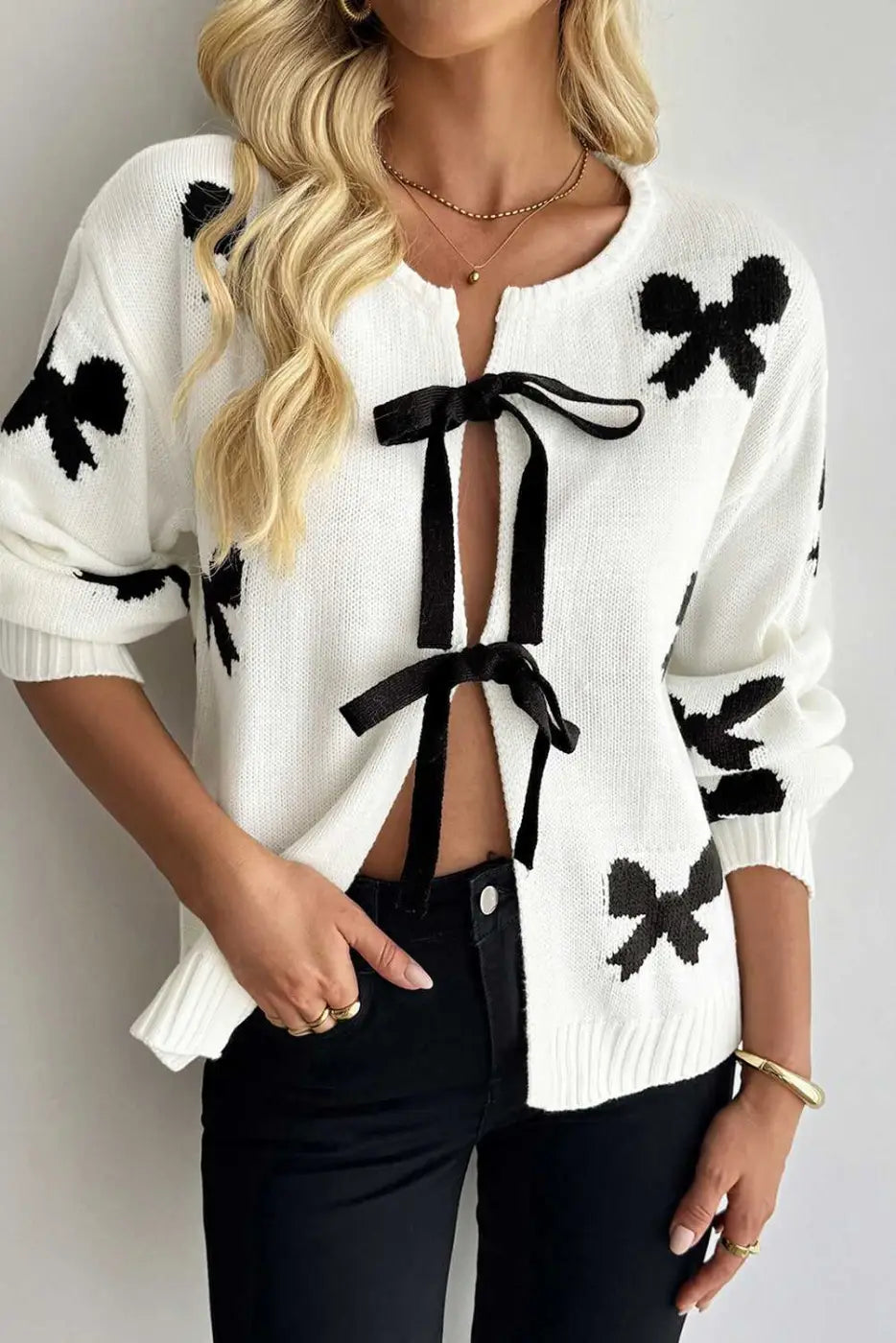 Soft White Bow‑Lace Knit Cardigan with black bow accents and open front ribbon ties, perfect for feminine and cozy seasonal layering.