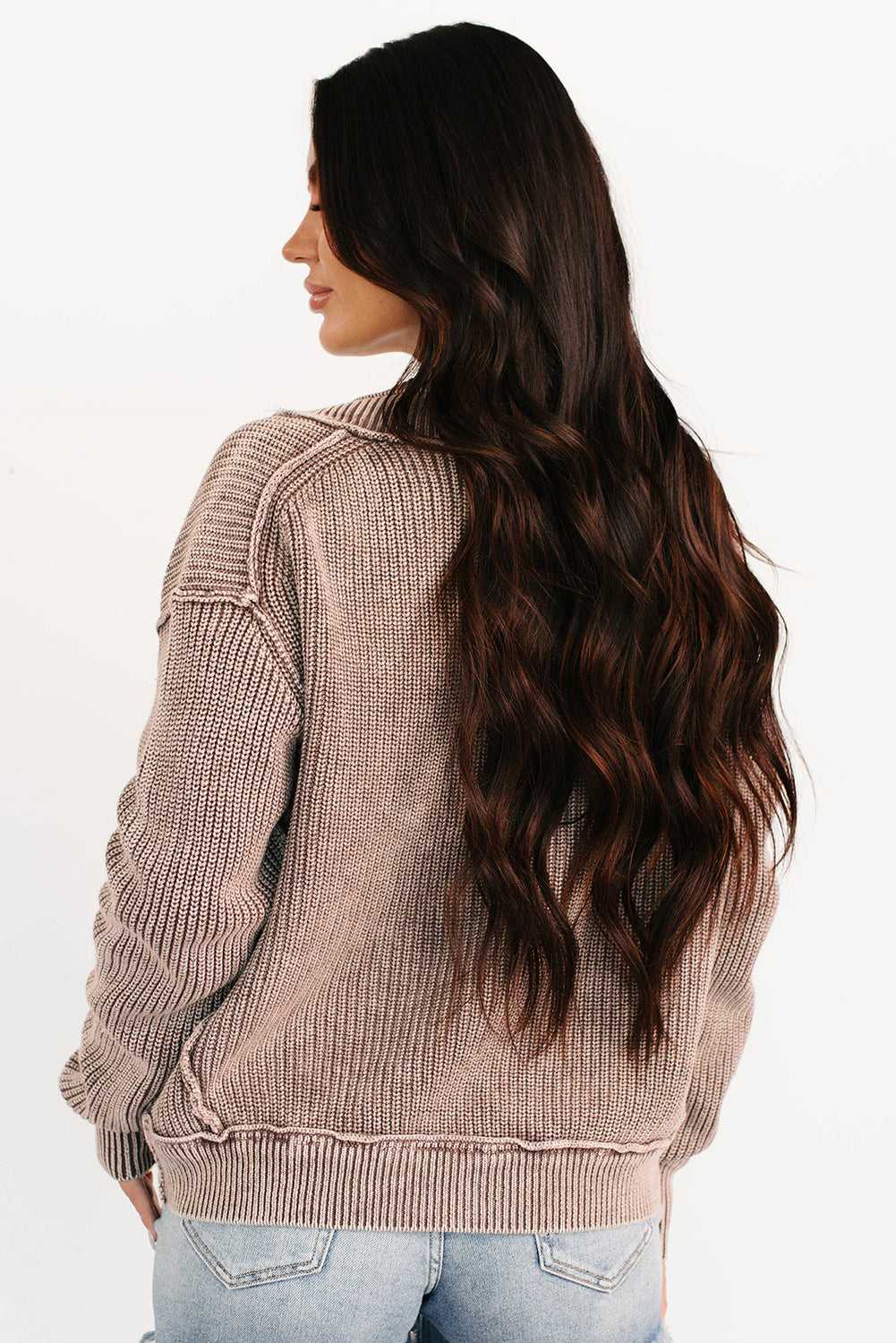Back view of woman in brown stonewash patchwork knit open cardigan showing ribbed knit texture and relaxed silhouette for fall fashion.