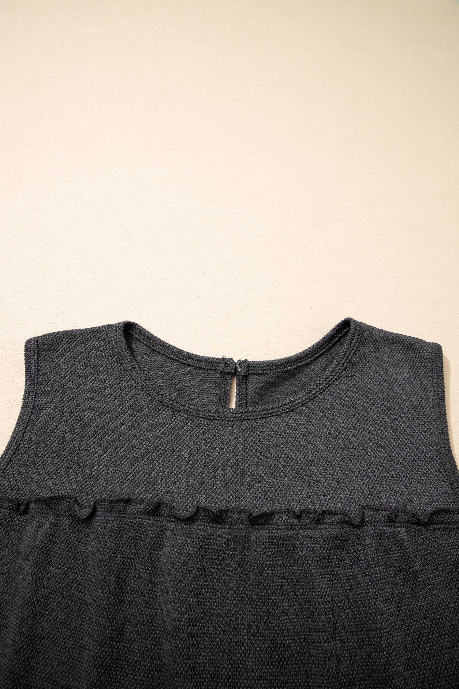 Close-up of neckline and button closure on dark grey tiered frill tank top for women, highlighting textured fabric.