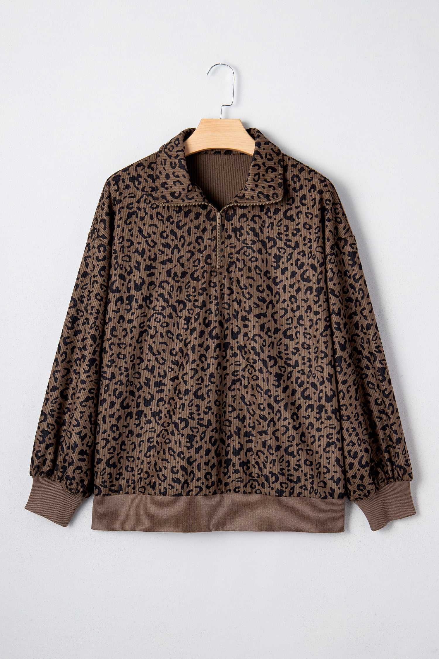 Women's brown leopard print corduroy half-zip jumper on hanger. Soft textured knit with ribbed cuffs and hem for casual wear.