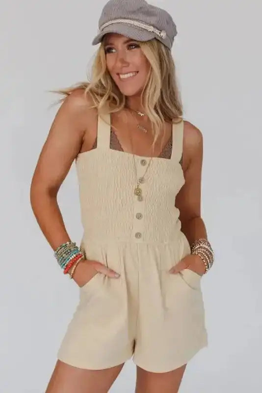 Beige Shirred Playsuit with front buttons and pockets, styled for a casual summer look. Light, breezy one-piece ideal for daily wear.